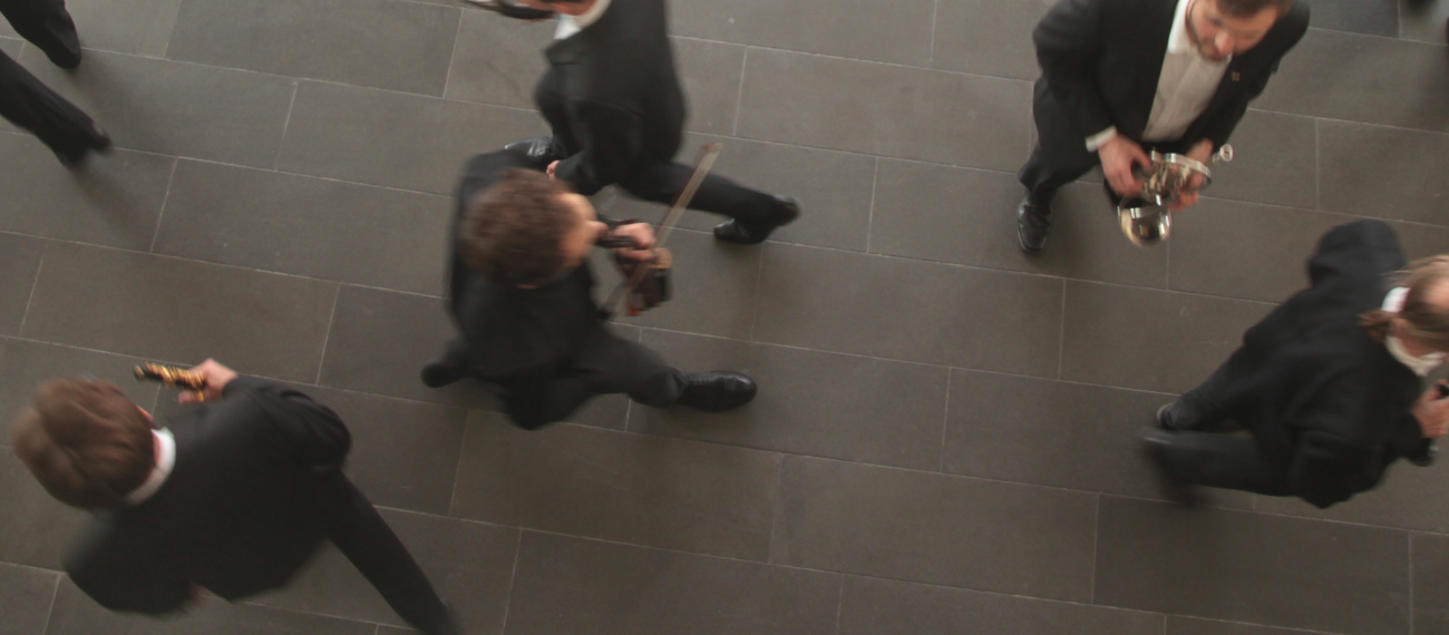 Orchestermitspielende im geschäftigen Treiben